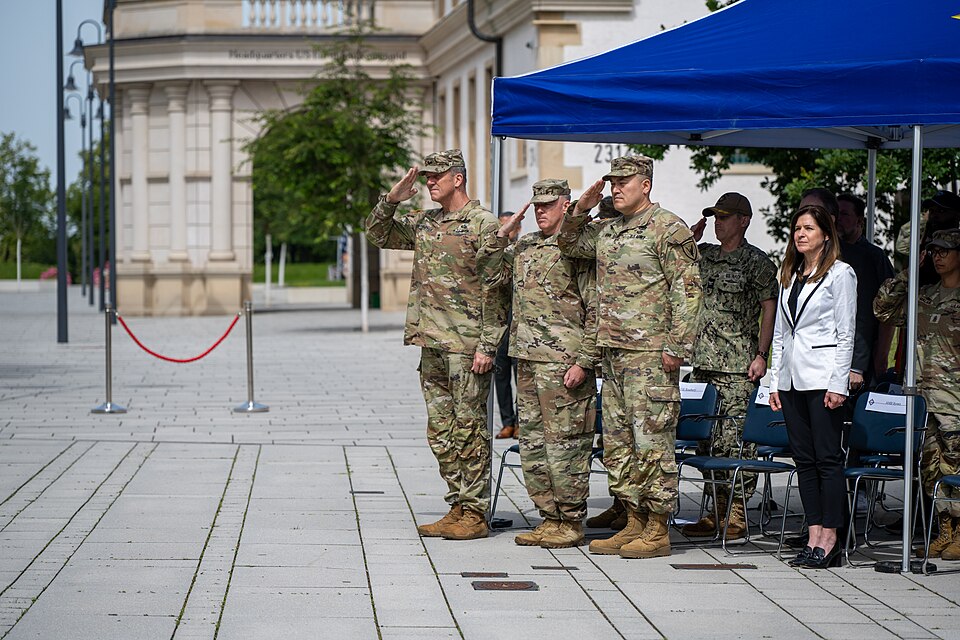 U.S. Army Major General Peter B. Andrysiak, USEUCOM Chief of Staff, Col Ryan K. Roseberry outgoing USEUCOM Headquarters Commandant, incoming USEUCOM Headquarters Commandant Col Loyd W. Brown, and Ambassador Kate Byrnes, Civilian Deputy Commander and Foreign Policy Advisor render honors to the nation