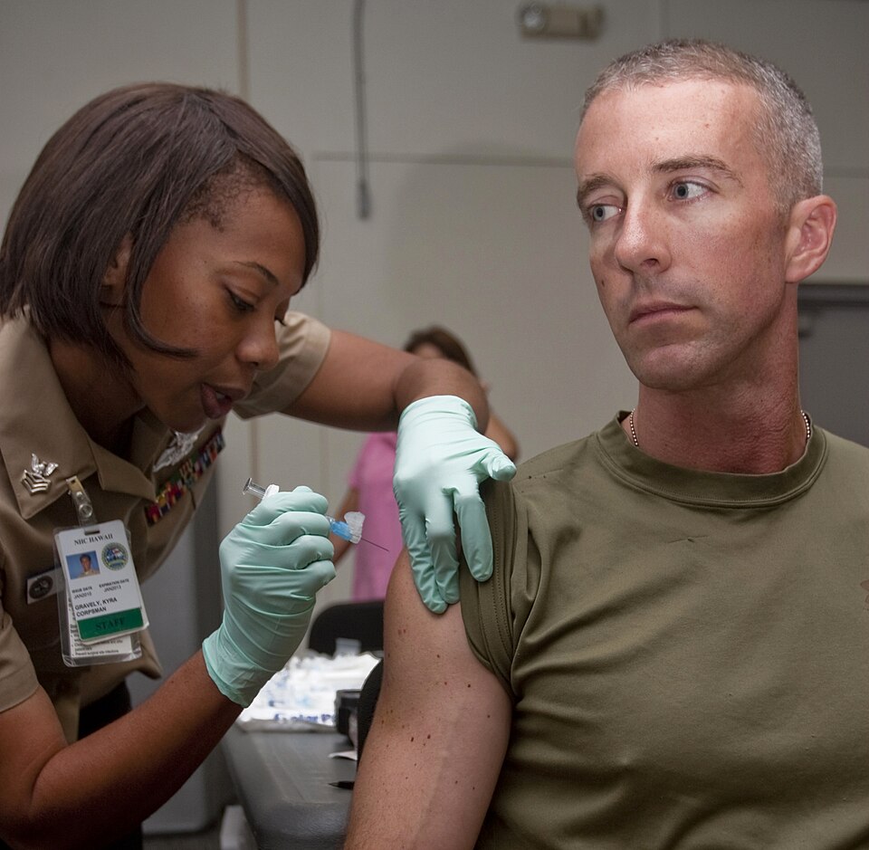 Petty Officer 1st Class Kyra Gravely, a hospital corpsman with Naval Health Clinic Hawaii’s Preventive Medicine Department, injects Capt. Jonathan Hayes, company commander for Headquarters Company, Headquarters and Service Battalion, U.S. Marine Corps Forces, Pacific, with an influenza vaccination O