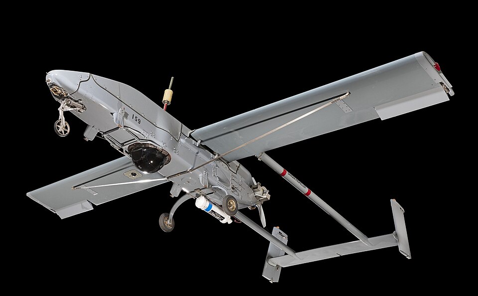 Unmanned Aerial Vehicle; Single engine; Pusher propeller; Twin tailbooms and rudders; Fixed tricycle undercarriage; Sensor package; Rocket assisted takeoff bottle included; Wings, tailbooms, tail assembly, and antenna breakdown for storage; Air Vehicle No. 159.; The RQ-2A provides field commanders w