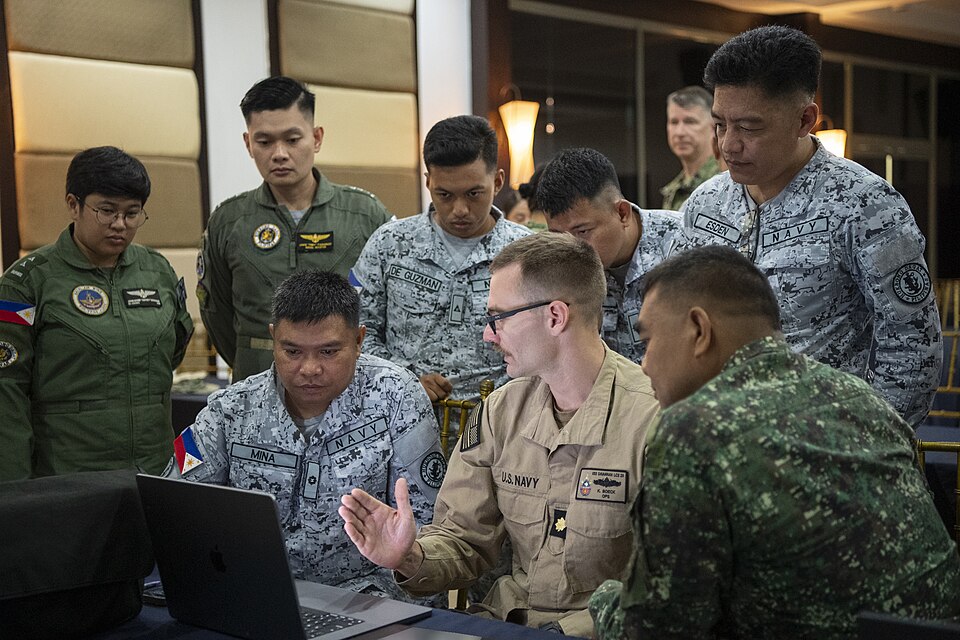 U.S. Navy Lt. Cmdr. Kyler Boeck, operations officer of the Independence-variant littoral combat ship USS Savannah (LCS 28), discusses joint-ship movement procedures with Philippine Navy Lt. Cmdr. Orlando Mina, Jr., for a multilateral maritime exercise in support of Exercise Balikatan 25. Balikatan i