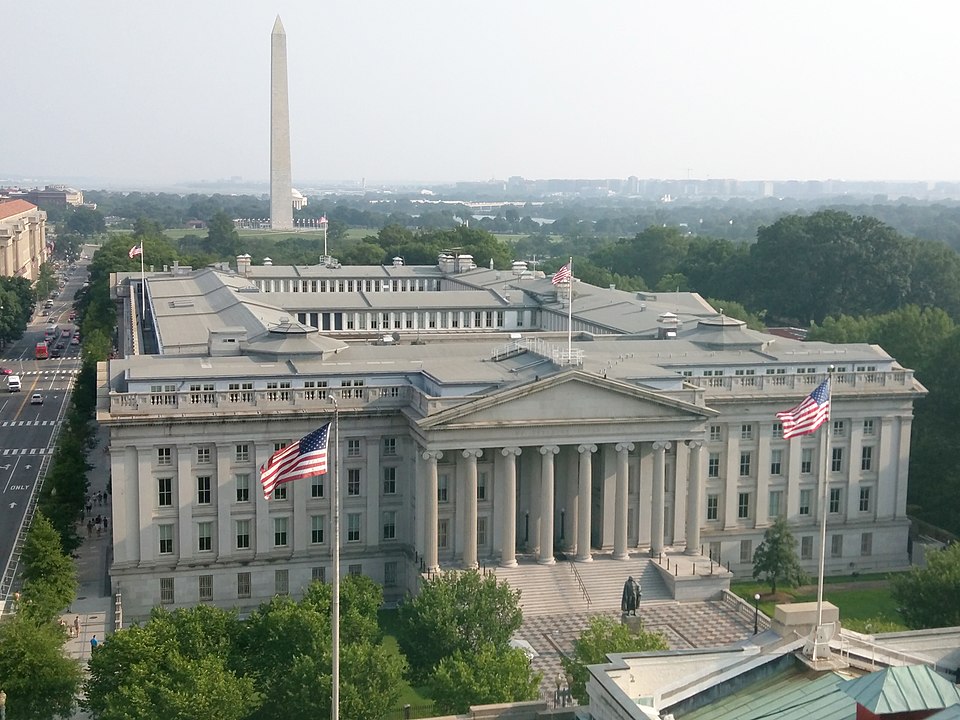 Photograph of the US Treasury building in Washington, DC. Washington Monument in the background.
