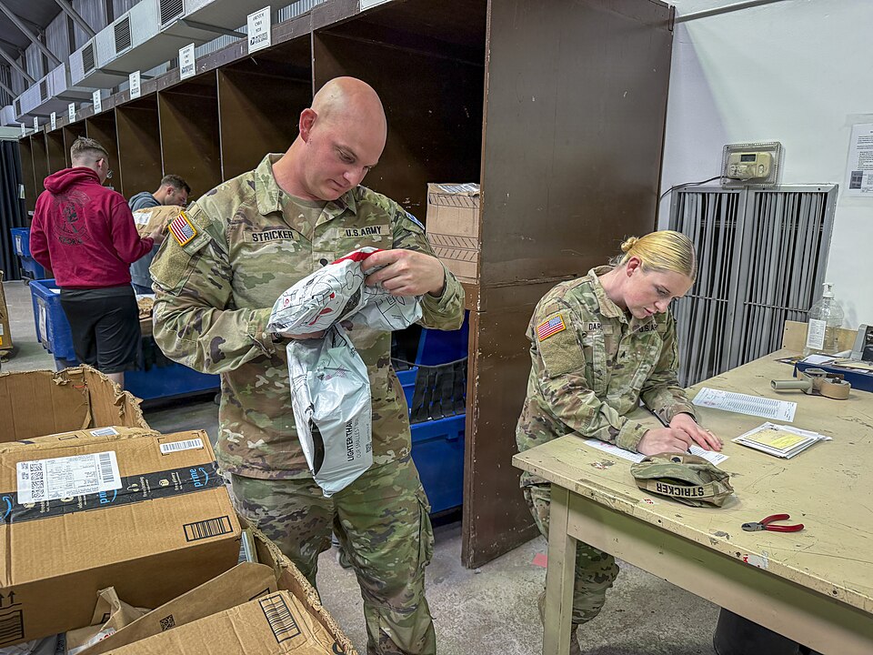 Florida Army National Guard Spc. Bruce Stricker, left, and Sgt. Lauren Darcy, both intel analysts with the 53rd Infantry Brigade Combat Team assigned to Kosovo Force (KFOR) Regional Command-East, verify and sort incoming mail at the military postal facility at Camp Bondsteel, Kosovo, April 15, 2026.