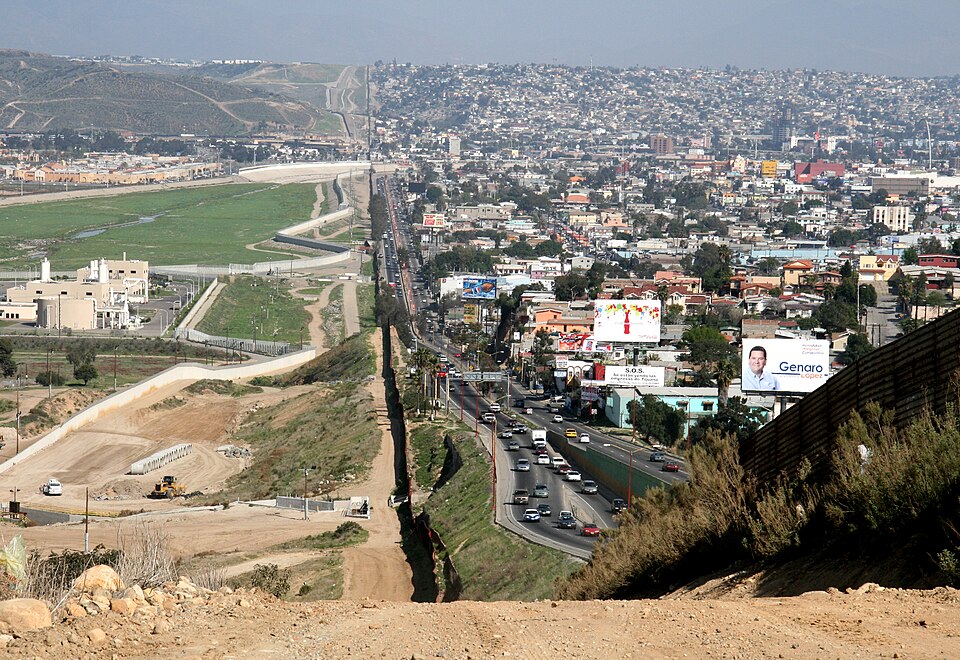 A small fence separates densely-populated Tijuana, Mexico, right, from the United States in the Border Patrol's San Diego Sector. Construction is underway to extend a secondary fence over the top of this hill and eventually to the Pacific Ocean.
