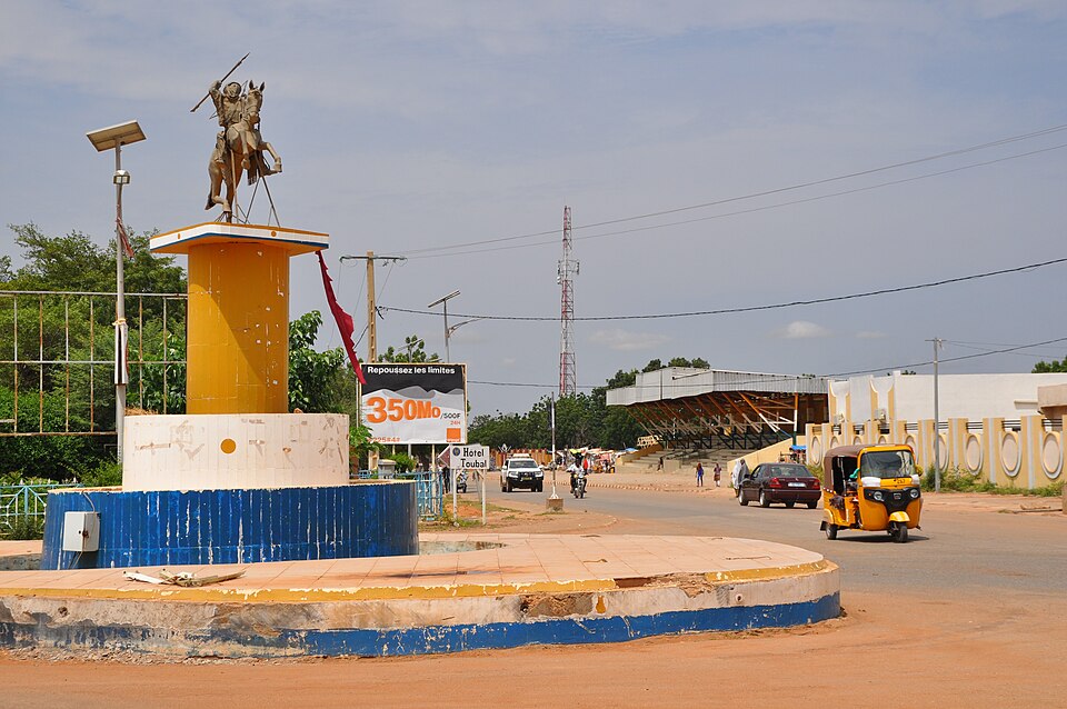 The city center of Dosso, Niger, with from left to right: the Place de Djermakoye (with statue), the Route Nationale No.1 (RN1, which is also called the "Boulevard du 15 Avril"), and the official grandstand (Dosso Department, Dosso Region).