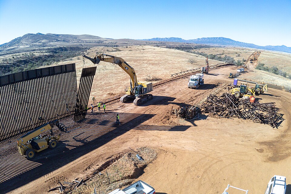 Workers install prefabricated panels as part of the new border wall system construction southwest of