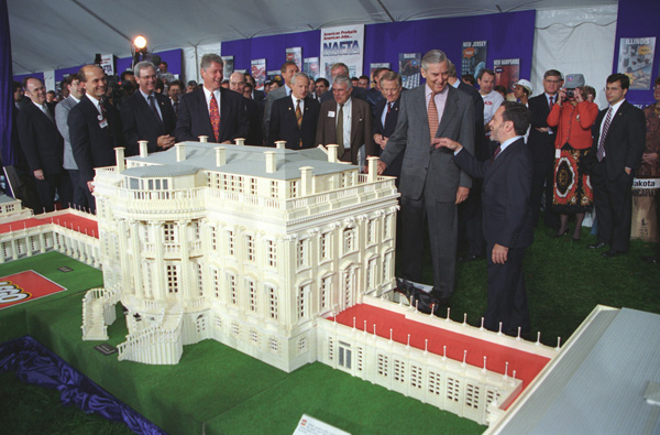 Scope and content:  This item is a photograph of President William J. Clinton looking at a Lego model of the White House exhibit at a NAFTA products event on the South Lawn of the White House.  The image was photographed by Sharon Farmer.
