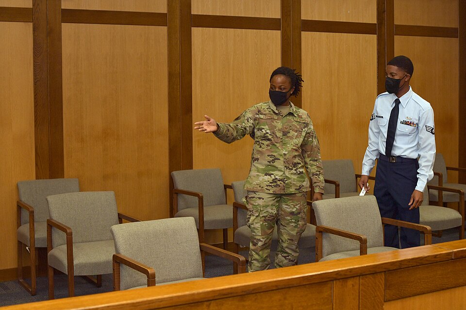 U.S. Air Force Tech. Sgt. Johne Tribble, 86th Airlift Wing Judge Advocate adverse actions noncommissioned officer in charge, explains the COVID-19 layout of the courtroom to Senior Airman Ja Micah D. Taylor Knight, 86th AW JA military justice paralegal, at Ramstein Air Base, Germany, Sept. 15, 2020.