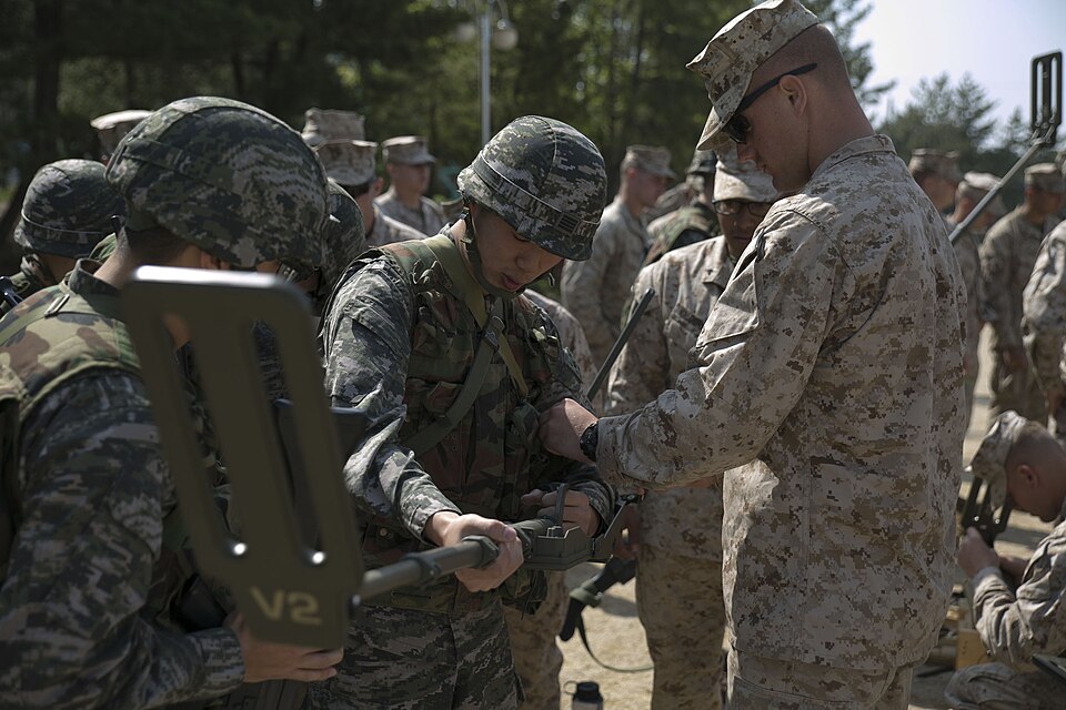 U.S. Marine Pfc. Mitchell W. Cialella, right, familiarizes Republic of Korea Marine Sgt. Kim Gi Yeok, center, with the U.S. Marine Corps’ method of using a metal detector April 21 during Korean Marine Exchange Program 14-6 in Pohang, Republic of Korea. KMEP is a series of exercises conducted regular
