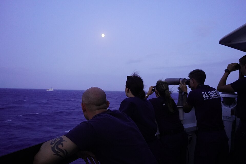 Cadet 1/c Matt Lubin, Ensign Lillia Farlow, Cmdr. Karen Kutkiewicz, Petty Officer 2nd Class Reese Davidson, and U.S. Merchant Marine Academy Midshipman Cole Hite observe the Coast Guard Cutter Venturous’ (WMEC 625) small boat crew conducting a transfer of detainees with the Coast Guard Cutter Forwar