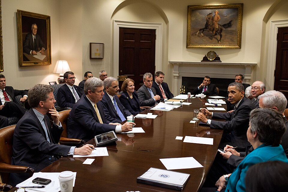 President Barack Obama drops by a meeting with Cabinet members in the Roosevelt Room of the White House, April 26, 2012. Seated clockwise from the President: Commerce Secretary John Bryson; Homeland Security Secretary Janet Napolitano; Housing and Urban Development Secretary Shaun Donovan; Agricultu