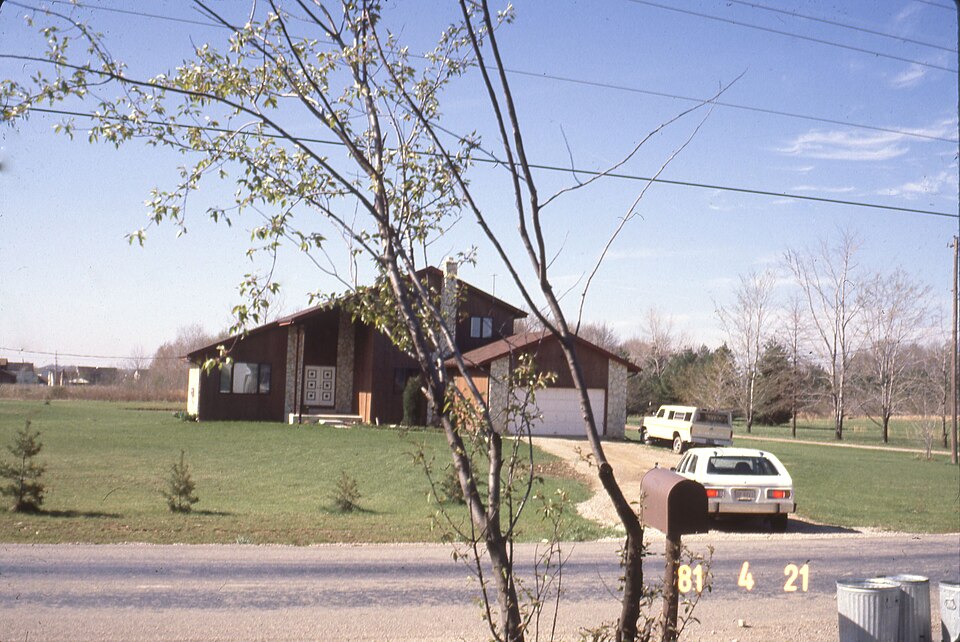 A view looking south across Summit View Road at the house at 2271 Summit View Road. Three metal trash cans next to a mailbox are in the bottom right corner. Two vehicles are in the driveway. See also: City of Columbus Rezoning Application: Z81-035 Location: 4.9± acres located on the south side of Su