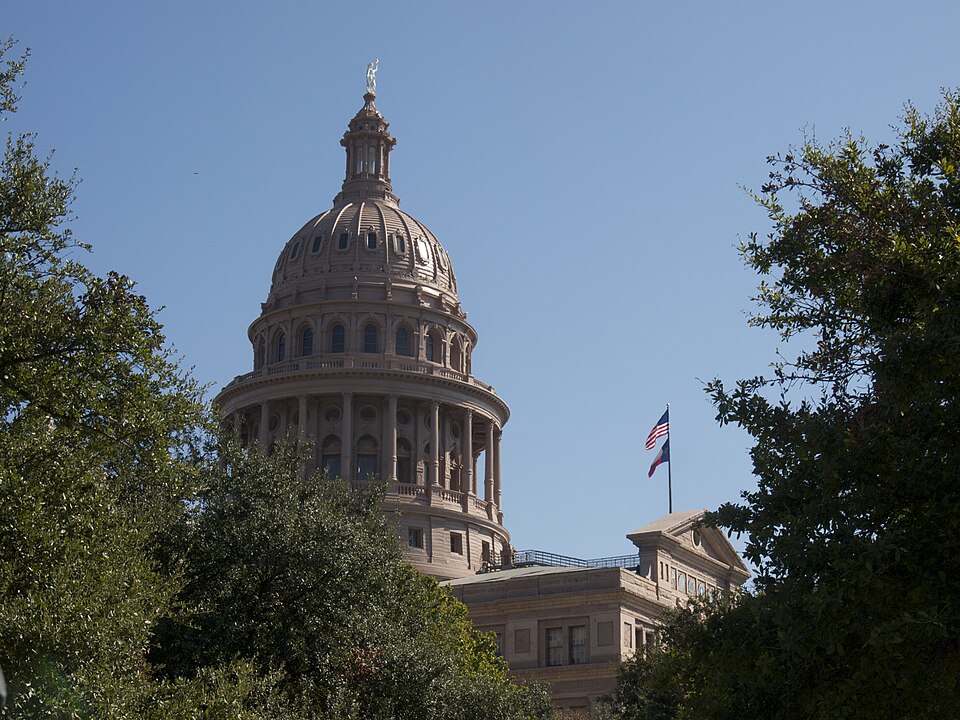 The Texas capitol building dome, with Goddess of Liberty and flags, during the 2014 Texas Book Festival.