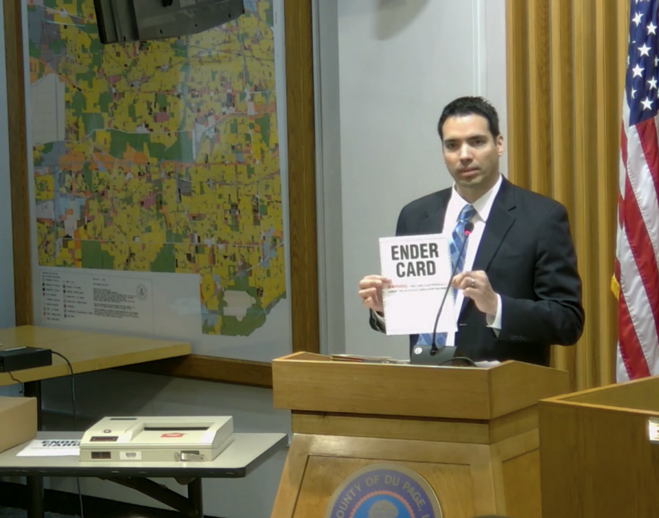 Joseph Sobecki, executive director of the DuPage County election commission, demonstrates an ender card on election equipment during a county board meeting held on March 27, 2018. A technical issue with the ender cards had led to delays in reporting results from the primary elections held on March 2