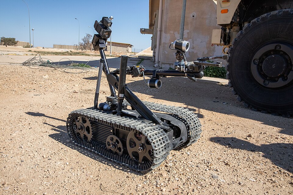 U.S. Army Soldiers assigned to the 774th Explosive Ordnance Disposal (EOD) Company set up an unmanned, tracked military robot to conduct a mock EOD sweep during a joint training exercise at Al Asad Air Base, Iraq, Feb. 24, 2025. The TALON robot is a small, remote-controlled robotic vehicle designed 