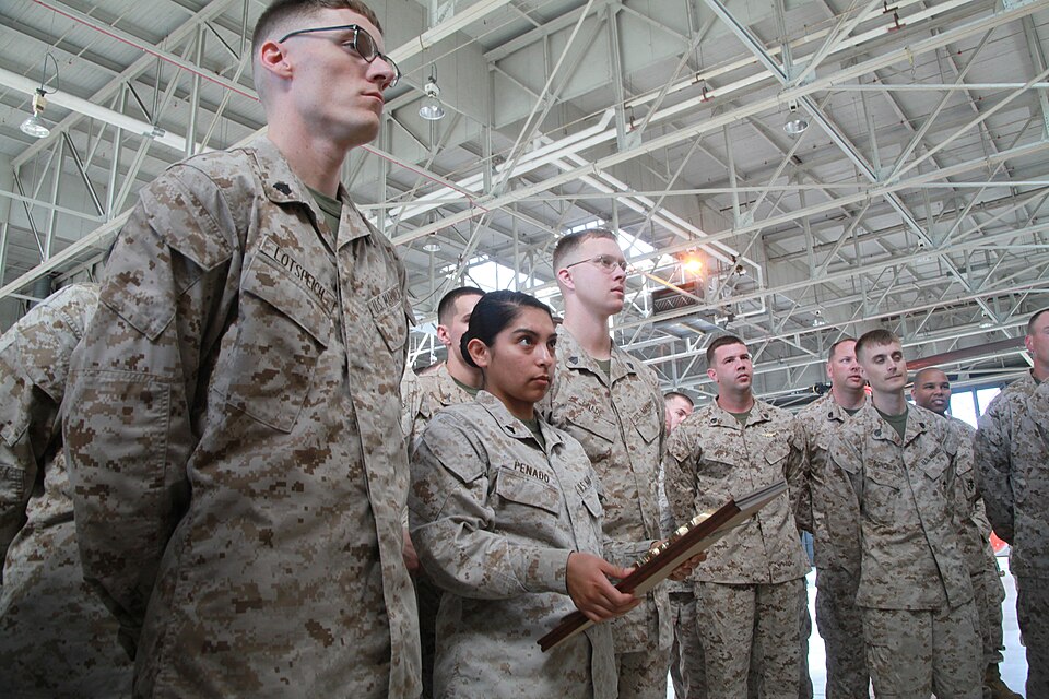 Cpl. Miriam Penado (middle), an aircraft electrical systems technician with Marine Transport Squadron 1, holds the Chief of Naval Operations award presented to VMR-1, June 27, by Brig. Gen. Thomas Gorry, the commanding general of Marine Corps Installation East. The CNO aviation safety award is an an