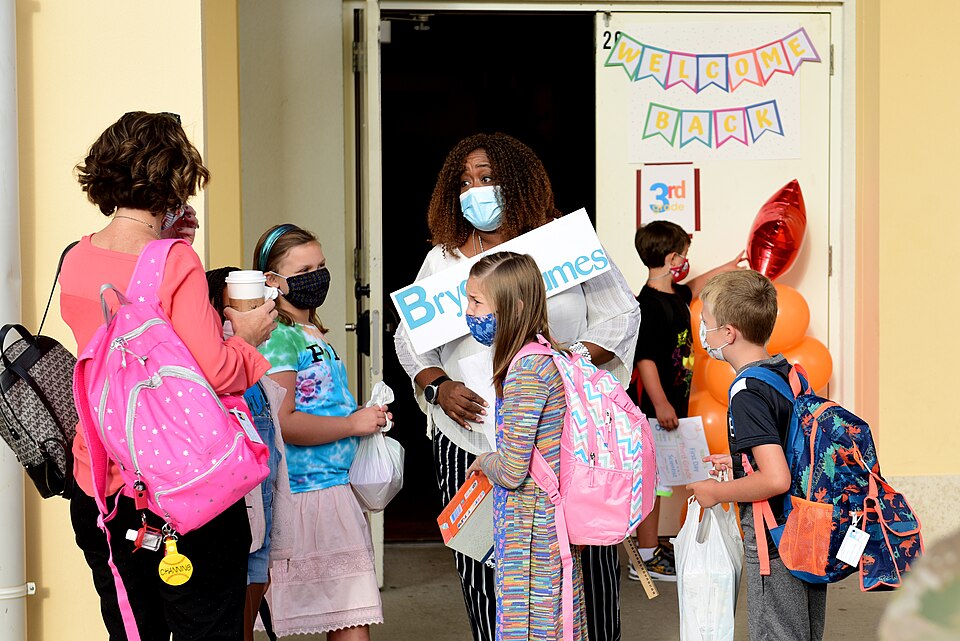 Children wait with their teacher to enter the school building at Aviano Air Base, Italy, Aug. 24, 2020. To adhere to U.S. Centers for Disease Control and Prevention and host nation requirements for COVID-19, entrances and exits will be designated for use by grade level. Other measures to hinder tran