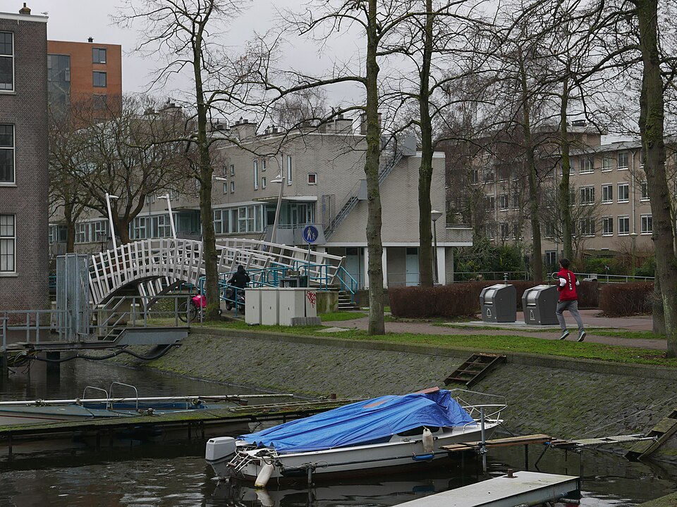 Residential buildings and gardens and urban trees in a small neighbourhood called Wittenburg; the small wooden footbridge is crossing the canal Kattenburgervaart; free photo Amsterdam city, Fons Heijnsbroek, 1601-2022