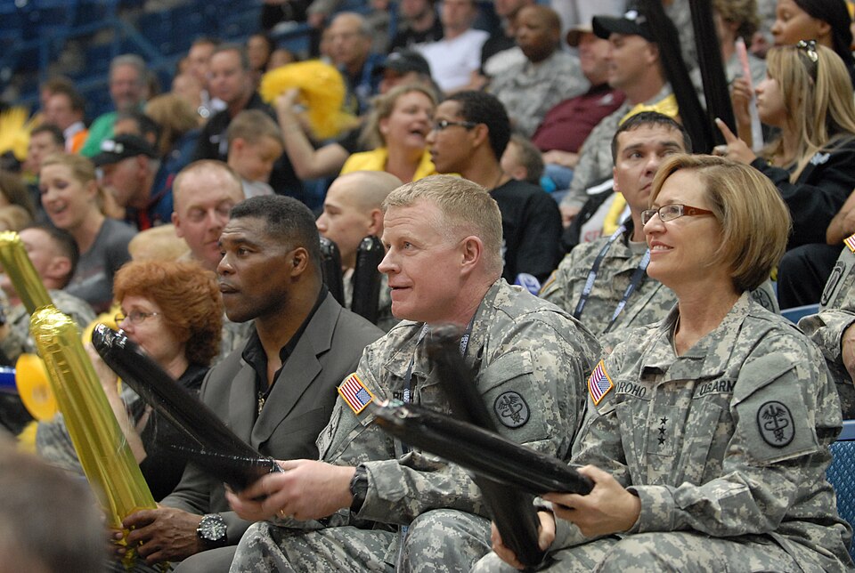 College Football Hall of Famer Hershel Walker (left) watches a wheelchair basketball game with U.S. Army Surgeon General, Lt. Gen. Patricia D. Horoho (right) and Brig. Gen. David J. Bishop, Assistant Surgeon General for Warrior Care and Transition, and commanding general of the U.S. Army Warrior Tra