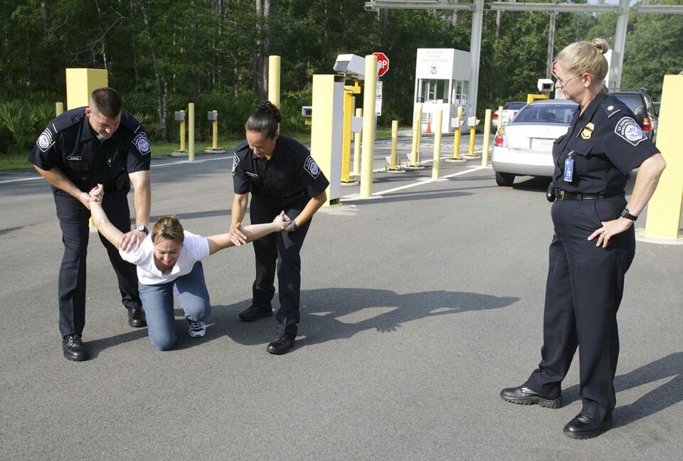 CBP Field Operations Academy at the Federal Law Enforcement Training Center in Glynco, Georgia, USA. CBP cadets train an arrest at the mock port of entry while overseen by a female CBP Instructor.