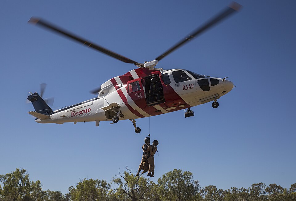 Marine Fighter Attack Squadron (VMFA) 122 U.S. Navy Lt. Matthew Case, flight surgeon, and U.S. Navy Petty Officer 3rd Class Juan Garcia, hospital corpsman, are hoisted into a Sikorsky S76A++ Search and Rescue helicopter while conducting SAR training during Exercise Pitch Black 2016 at Royal Australi