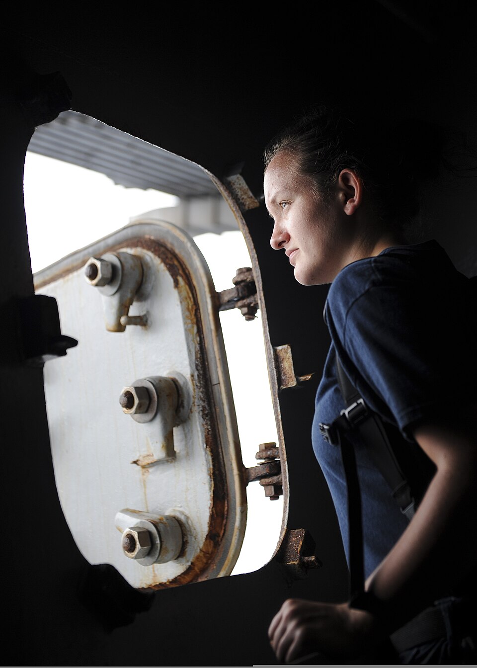 U.S. Navy Seaman Apprentice Crystal Hingtgen, assigned to the deck department aboard the aircraft carrier USS Nimitz (CVN 68), looks at the ocean from an open hatch aboard the ship Aug. 2, 2013, in the Gulf of Oman. The Nimitz Carrier Strike Group was deployed to the U.S. 5th Fleet area of responsib