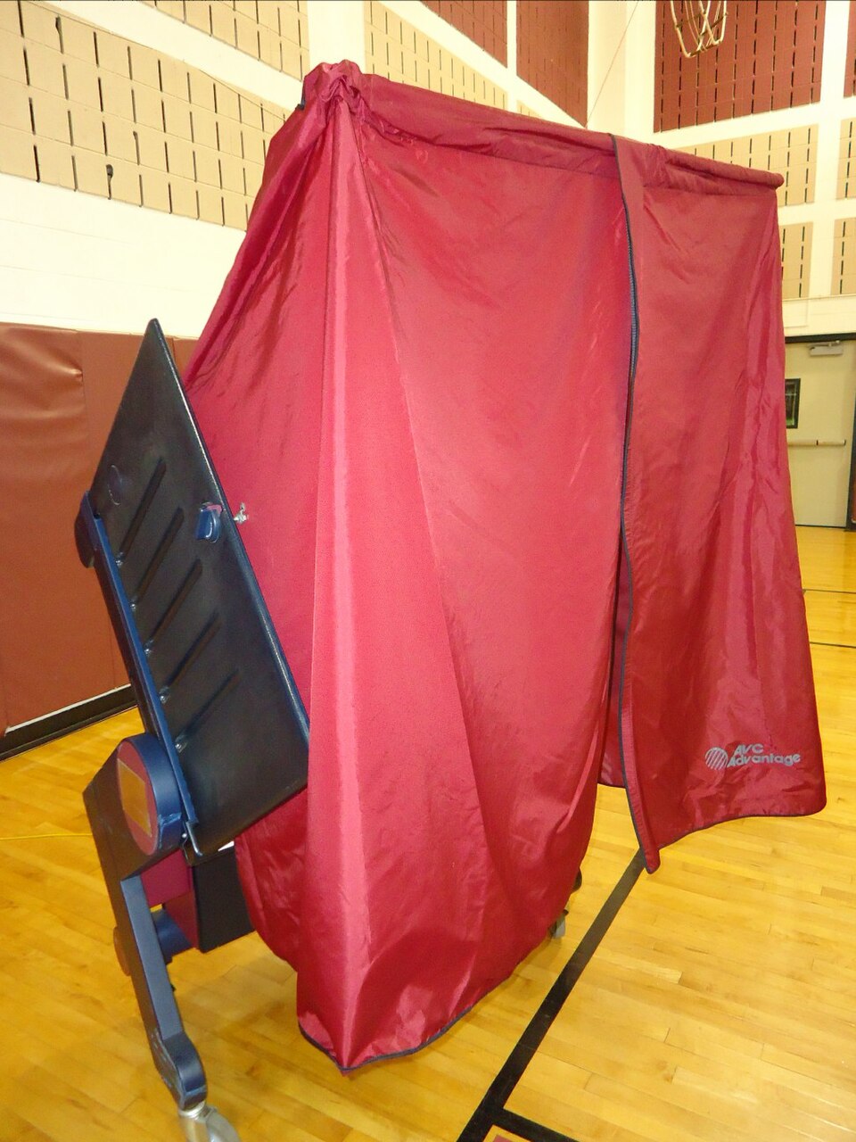 Voting booth in Summit, New Jersey. A voter hands a paper slip written by a registration checker to the attendant (not shown) and then walks in, makes selections, and then walks out.