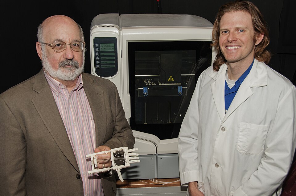 Dr. Steven Pollack (left), Director of FDA’s Office of Science and Engineering Laboratories (OSEL) at FDA’s Center for Devices and Radiological Health (CDRH)  holds a 3D-printed RoboHand, a prosthetic for children with amnionic banding syndrome, an illness that can prevent fingers from developing in