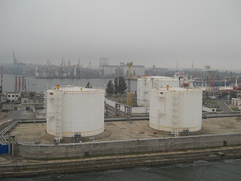 Odesa Port - Oil Mole (Jetty)
Location: Ukraine, Odeska, Odesa
Coordinates: 46°30'42"N 30°44'1"E
Wikimapia description:

Caption:

Three large white cylindrical tanks with metal ladders stand on a concrete platform beside a waterway. Behind them, industrial cranes and silos line the foggy harbor. Th