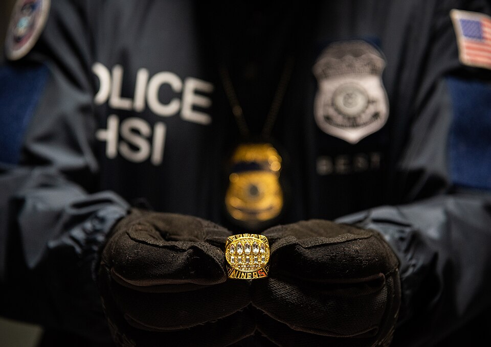 A Homeland Security Investigations special agent holds up a counterfeit Super Bowl ring that was seized at a mail sorting facility during Super Bowl LIV. 
The seizures were part of Operation Team Player, an ongoing effort developed by the HSI-led Intellectual Property Rights (IPR) Center to target t