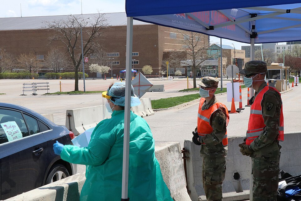 Iowa National Guard Soldiers of the 186th Military Police Company operate a traffic control point with a local medical health care professional at the COVID-19 testing site at the Iowa Events Center in Des Moines, Iowa, on April 25, 2020. The Soldiers were called to State Active Duty in order to sup