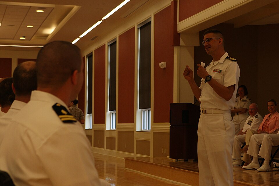 Navy Capt. Mark Stephens, associate professor and chair of the Department of Family Medicine, Uniformed Services University of the Health Sciences, speaks to Naval Hospital Camp Lejeune interns and residents during the Family Medicine Residency program graduation at Marston Pavilion aboard Marine Co