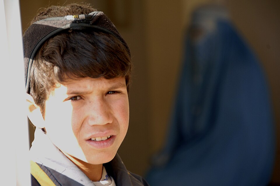 A Afghan boy stands at the entrance of a comprehensive health clinic while he waits for his mother to receive medical attention.  This clinic is one of the many that the Bagram Provincial Reconstruction Team has funded.