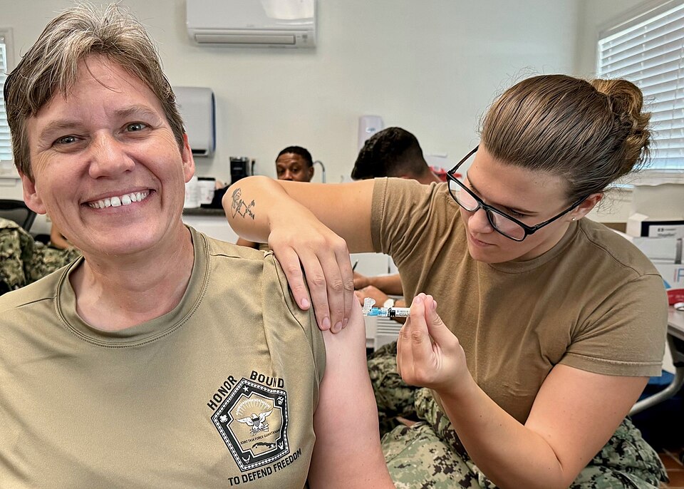 GUANTANAMO BAY, Cuba – Hospital Corpsman Alexandra Oosterom, an occupational health technician, administers an influenza vaccine to Capt. Tammy Servies, commanding officer of U.S. Navy Medicine Readiness and Training Command and director of U.S. Naval Hospital Guantanamo Bay, Sept. 24, 2024. More th