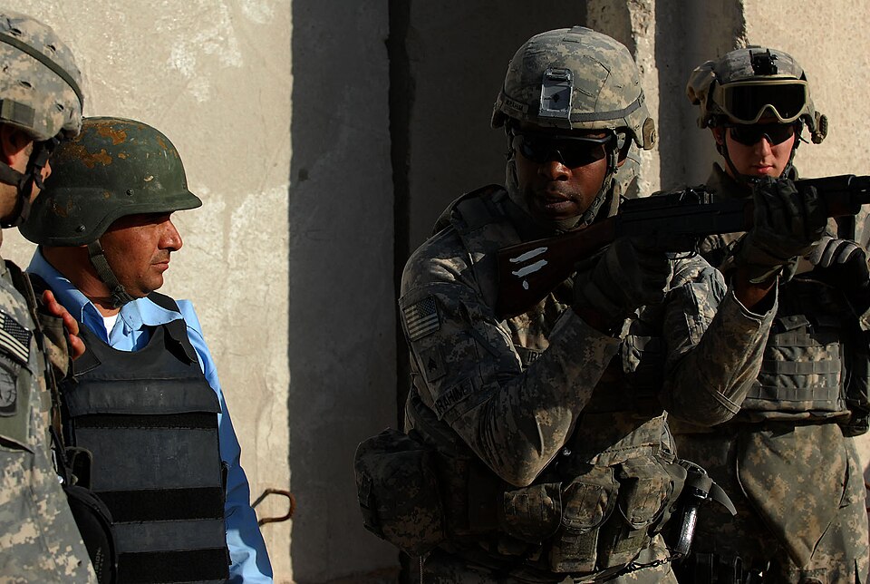Sgt. Abdul Ibrahim, a native of New York City,  3rd Platoon, 300th Military Police Company, currently attached to the 19th Military Police Battalion, 18th Military Police Brigade, 4th Infantry Division, Multi-National Division--B, demonstrates a proper shooting stance with an AK-47 rifle to an Iraqi