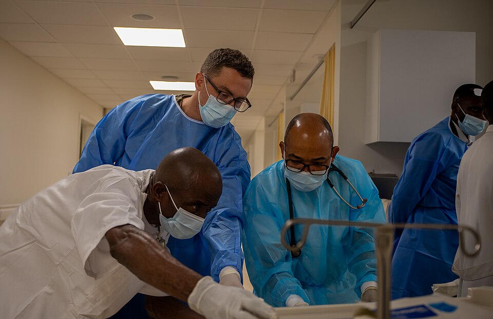 U.S. Army Capt. Trent Mullenburg, an emergency room nurse (66T), center, assists Angolan Army health professionals in identifying equipment needed for an Angolan patient with HIV and malaria. Mullenburg, assigned to the 934th Forward Resuscitative Surgical Detachment, worked alongside Angolan milita