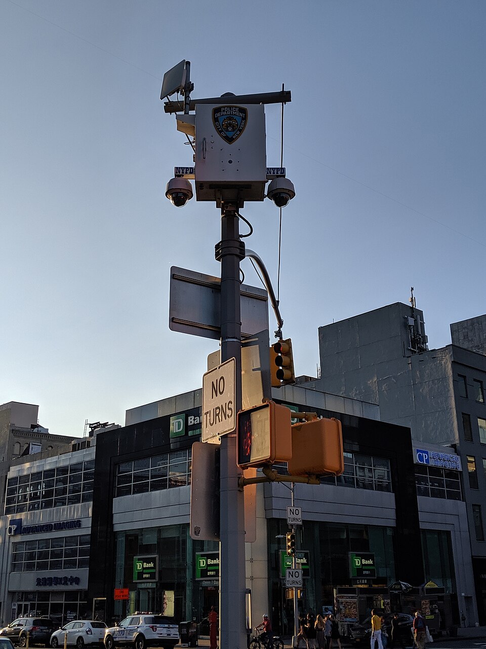 Housing for electronics on a pole in NYC, including two dome security cameras and a secondary device in the air. Appears to be an Argus camera.