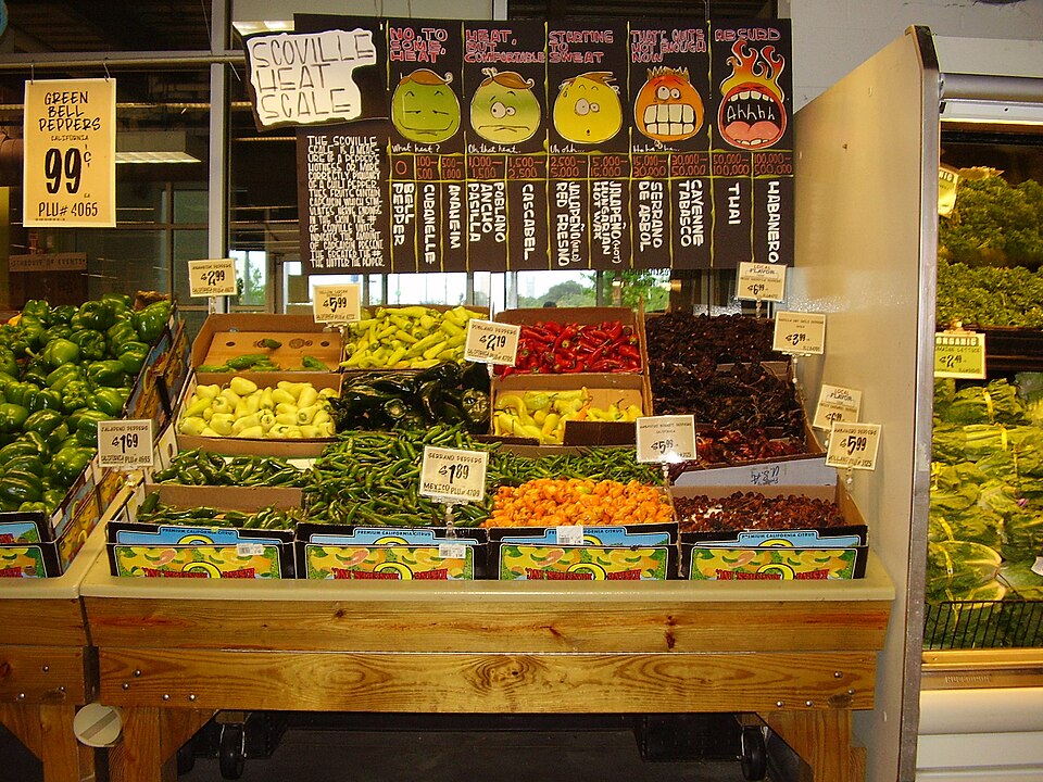A display of hot peppers and a board explaining the Scoville scale at the H-E-B Central Market location in Houston, Texas - Art by Lisa Stewart