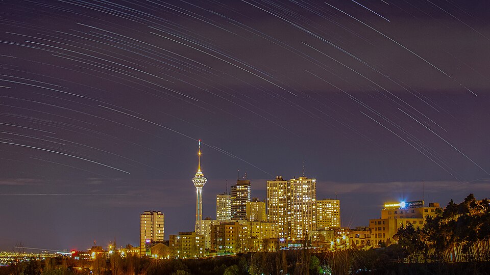 Milad Tower, located in Tehran, Iran, is the sixth tallest tower in the world at 435 meters (1,427 ft). It serves as a telecommunications and observation tower and is a prominent symbol of Tehran’s skyline. Long exposure captures star trails above Tehran, with Milad Tower standing prominently in the