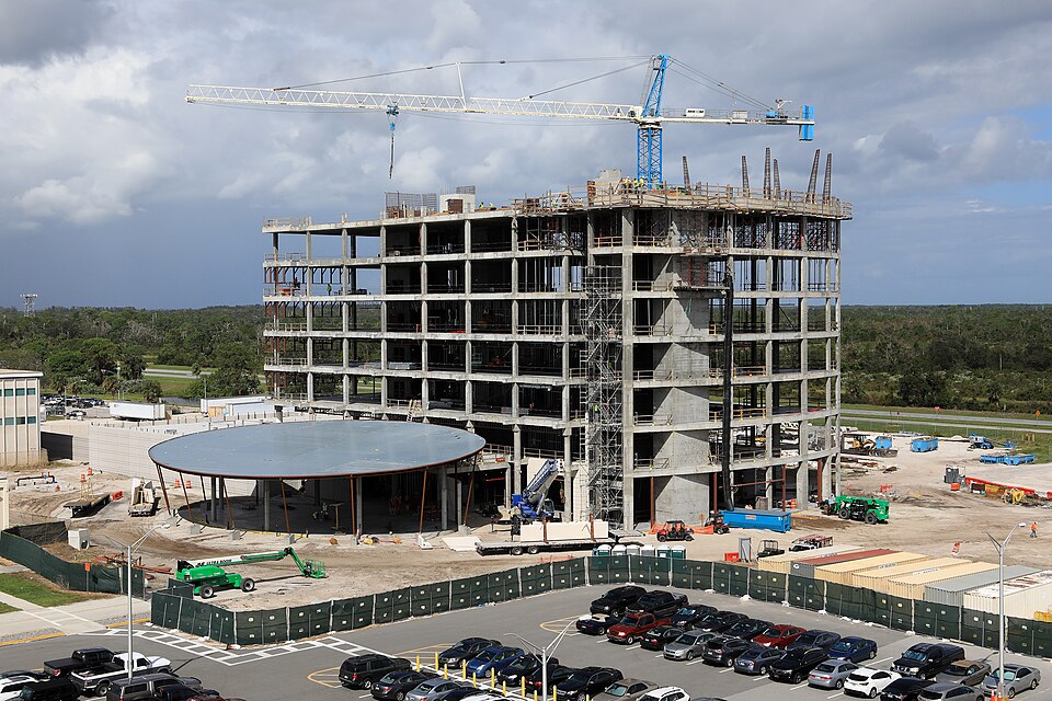 A large crane towers overhead as the new, seven-story headquarters building takes shape in the industrial area at NASA’s Kennedy Space Center in Florida. The 200,000-square-foot facility will anchor the spaceport’s Central Campus and house about 500 NASA civil service and contractor employees. The b