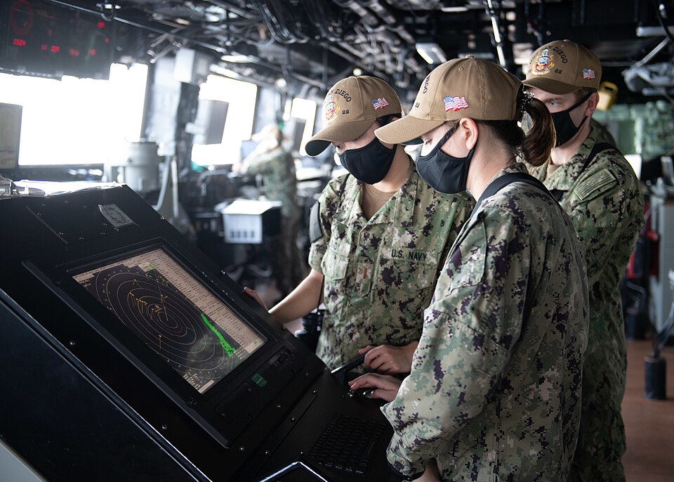 STRAIT OF HORMUZ (March 24, 2021) Ensigns Margaret Brady, left, and Kellyn Abbanat track surface contacts using radar on the bridge aboard the amphibious transport dock ship USS San Diego (LPD 22) while transiting the Strait of Hormuz, March 24, 2021. San Diego, part of the Makin Island Amphibious R