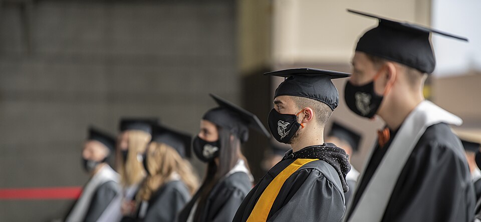 The Spangdahlem High School (SHS) class of 2020 observes the graduation stage while donned in customized facemasks and sitting 2 meters apart from each other at Spangdahlem Air Base, Germany, June 6, 2020. Due to the COVID-19 pandemic, Spangdahlem High School coordinated an innovative "drive-in" sea