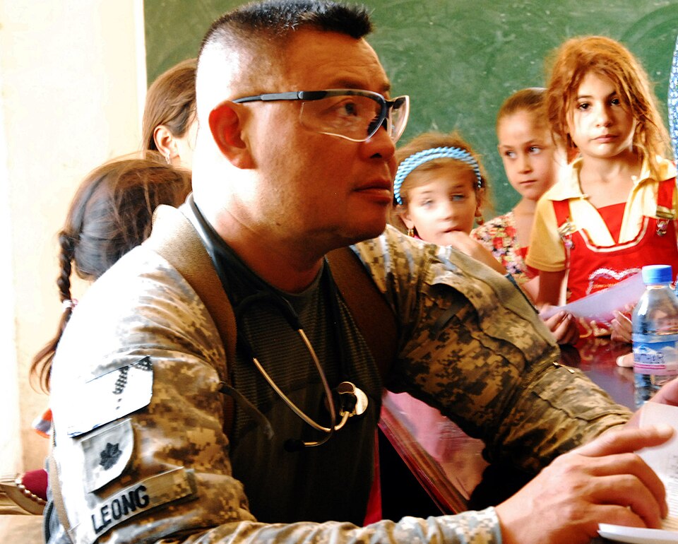Lt. Col. Jonathan Leong, surgeon assigned to the 3rd Battalion, 15th Infantry Regiment, 4th Advise and Assist Brigade, 3rd Infantry Division, United States Division – Center, treats women and children at a free clinic during an Iraqi Security Forces-led medical engagement Sept. 7 in Karmah, Iraq. U.