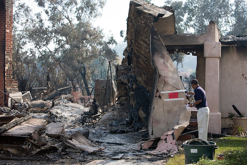 Rancho Bernardo, CA, October 28, 2007 -- A FEMA Community Relations specialist walks through a Rancho Bernardo neighborhood distributing disaster information to fire victims.
Andrea Booher/FEMA