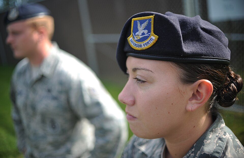 U.S. Air Force Staff Sgt. Stacy Glass, foreground, assigned to the 673rd Air Base Wing, 673rd Security Forces Squadron, listens to a military working dog briefing during a training session at Joint Base Elmendorf-Richardson, Alaska, Aug. 26, 2013. The Airmen trained with their K-9 counterparts to pr