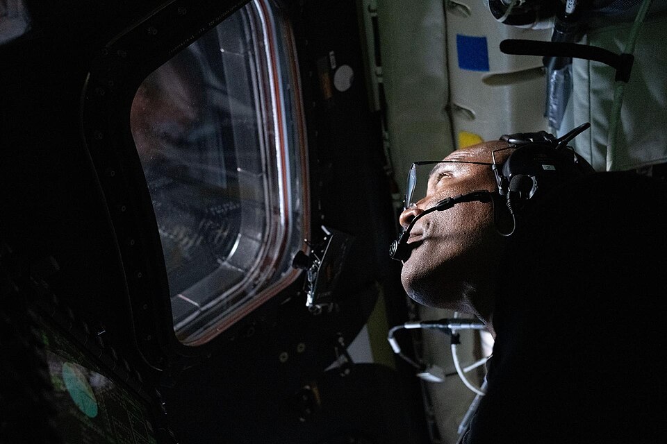 art002e016204 (April 6, 2026) – NASA astronaut and Artemis II Pilot Victor Glover pictured here in the Orion spacecraft during the Artemis II lunar flyby. Glover and his fellow crewmates spent approximately seven hours taking turns at the Orion windows capturing science data to share with their team