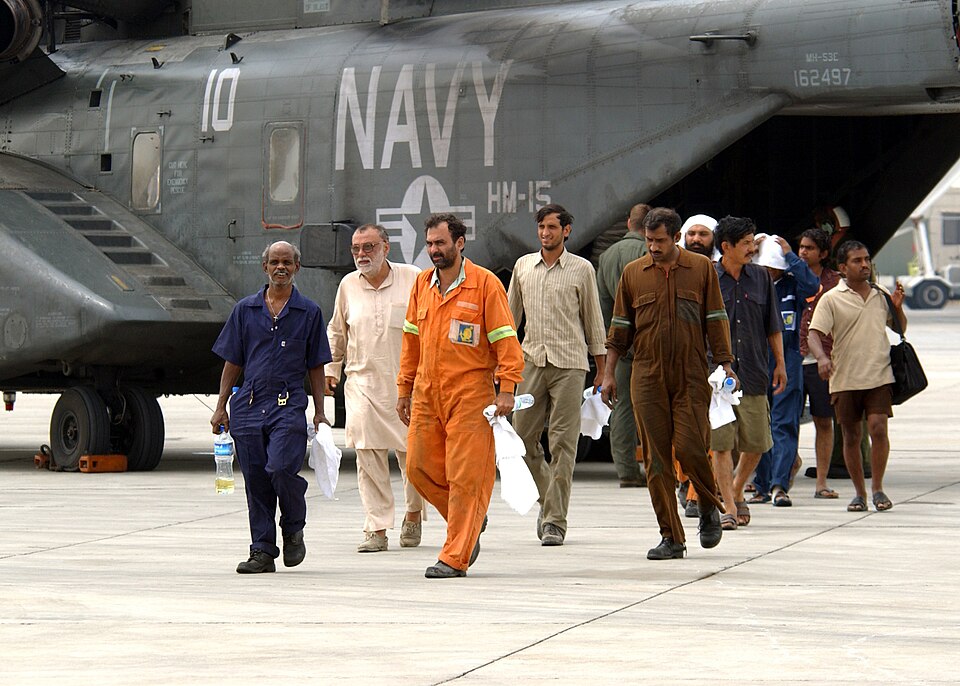 Manama, Bahrain (May 12, 2005) - Motor Vessel Olympias crew members arrive at the aviation unit of Naval Support Activity, Bahrain, after being rescued at sea by Sailors assigned to the guided missile destroyer USS Mustin (DDG 89). Mustin Sailors rescued 27 people from the Olympias after an engine-r
