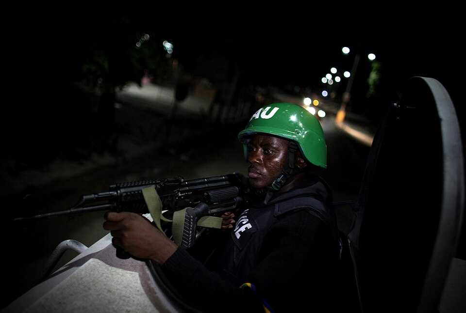 A Nigerian police officer serving with a Formed Police Unit (FPU) of the African Union Mission in Somalia (AMISOM) mans a gun turret on a armoured personnel carrier as a convoy drives along a main street of the Somali capital Mogadishu during a joint night patrol and snap-vehicle checkpoint exercise
