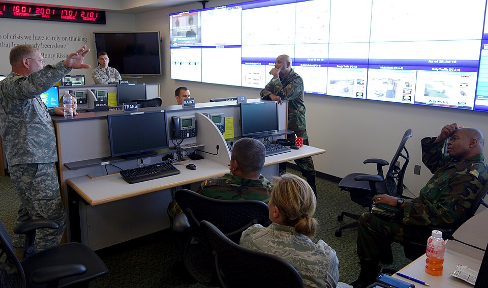 U.S. Army Col. Thomas Croymans, left, South Dakota National Guard’s director of the joint staff, shows members of Suriname’s Defense Forces the SDNG’s Joint Operations Center at Camp Rapid in Rapid City, S.D., July 28, 2015. The Surinamese service members were in South Dakota on a subject matter exp