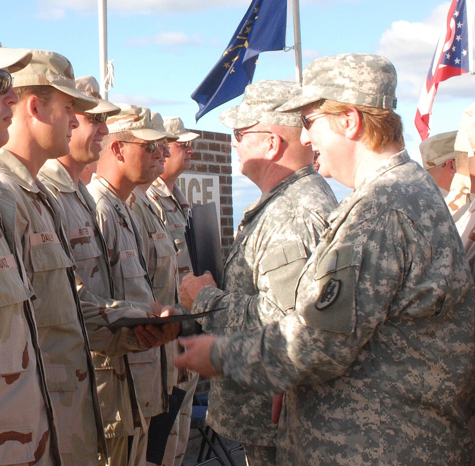 Army Col. Wendy Kelly and Army Sgt. 1st Class Domini McDonald present members of the 474th with Cert
