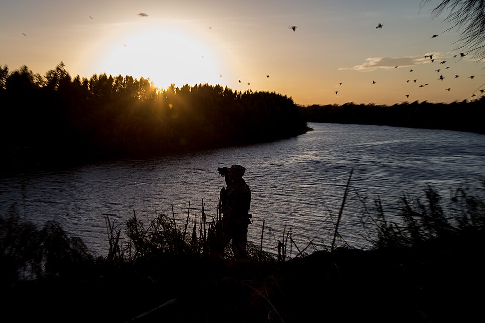 A soldier from the 36th Infantry Division, Texas Army National Guard observes a section of the Rio Grande River at sunset. He is serving at the Texas-Mexico border in support of Operation Strong Safety. (U.S. Army photo by Maj. Randall Stillinger)